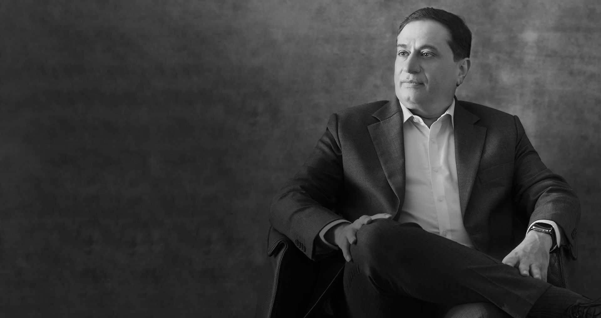 Textured dark backdrop behind the founder